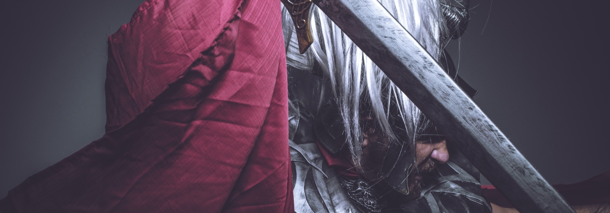 Roman gladiator, wrestler and warrior of Rome with helmet and red cloak, carries an iron sword, beard and long hair. Spiritual Warfare.