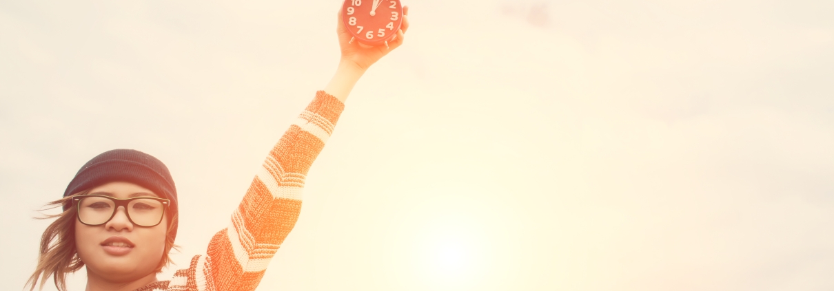 Young woman holding and throw alarm clock to the sky depicting awake to righteousness