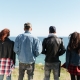 Back view image of a group of friends standing outdoors near the beach. Are they unequally yoked?