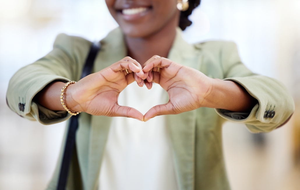 Black woman,with a loyal heart uses her hands to make a heart to show gratitude, support and compassion.