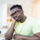 Close up profile view of pensive upset African American man look in distance thinking of personal problems, thoughtful sad biracial male feel depressed lost in thoughts pondering, having dilemma