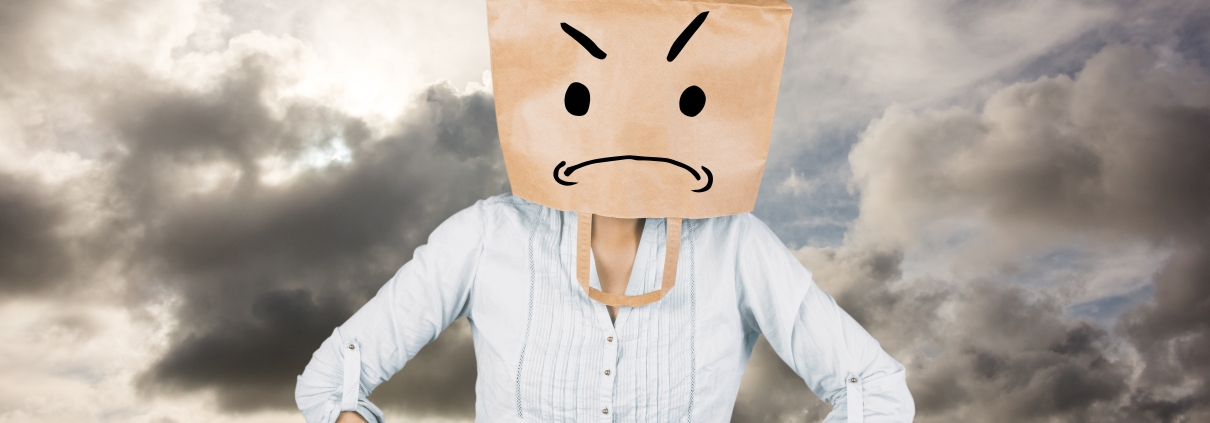 Woman feeling like a fraud where parents feel like imposters with hands on hip and covering head with brown paper bag against blue sky with white clouds