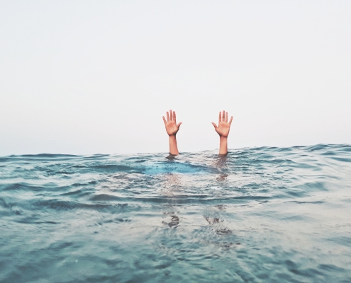cropped-hands-person-emerging-from-sea-against-clear-sky