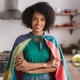 front-view-young-beautiful-housewife-green-shirt-colorful-cape-posing-smiling-white-bac