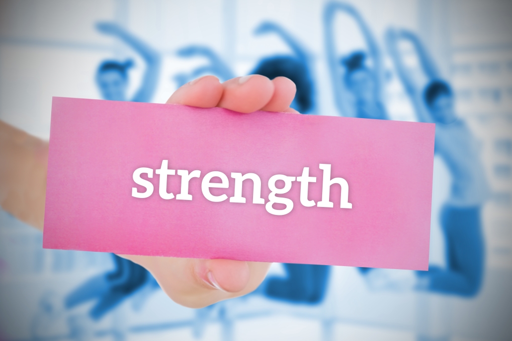 Woman holding pink card saying strength representing strength and dignity